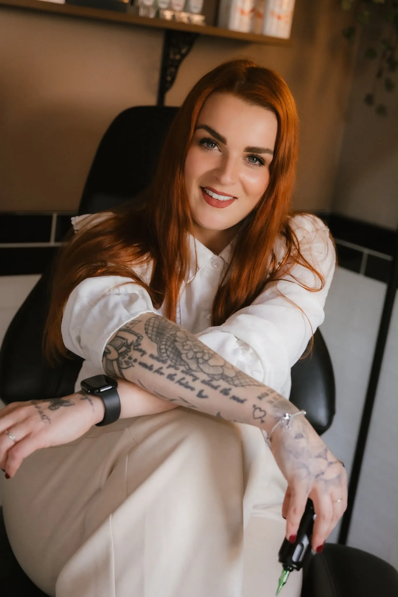 Laura zit in haar tattoo stoel en toont haar getatoeëerde arm