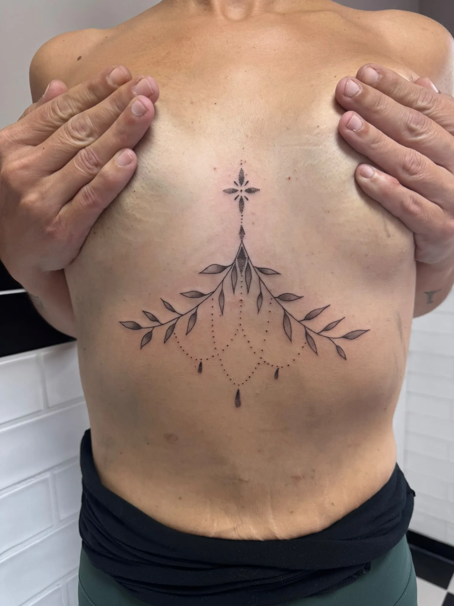 Ornamentale sternum tattoo met bladranken