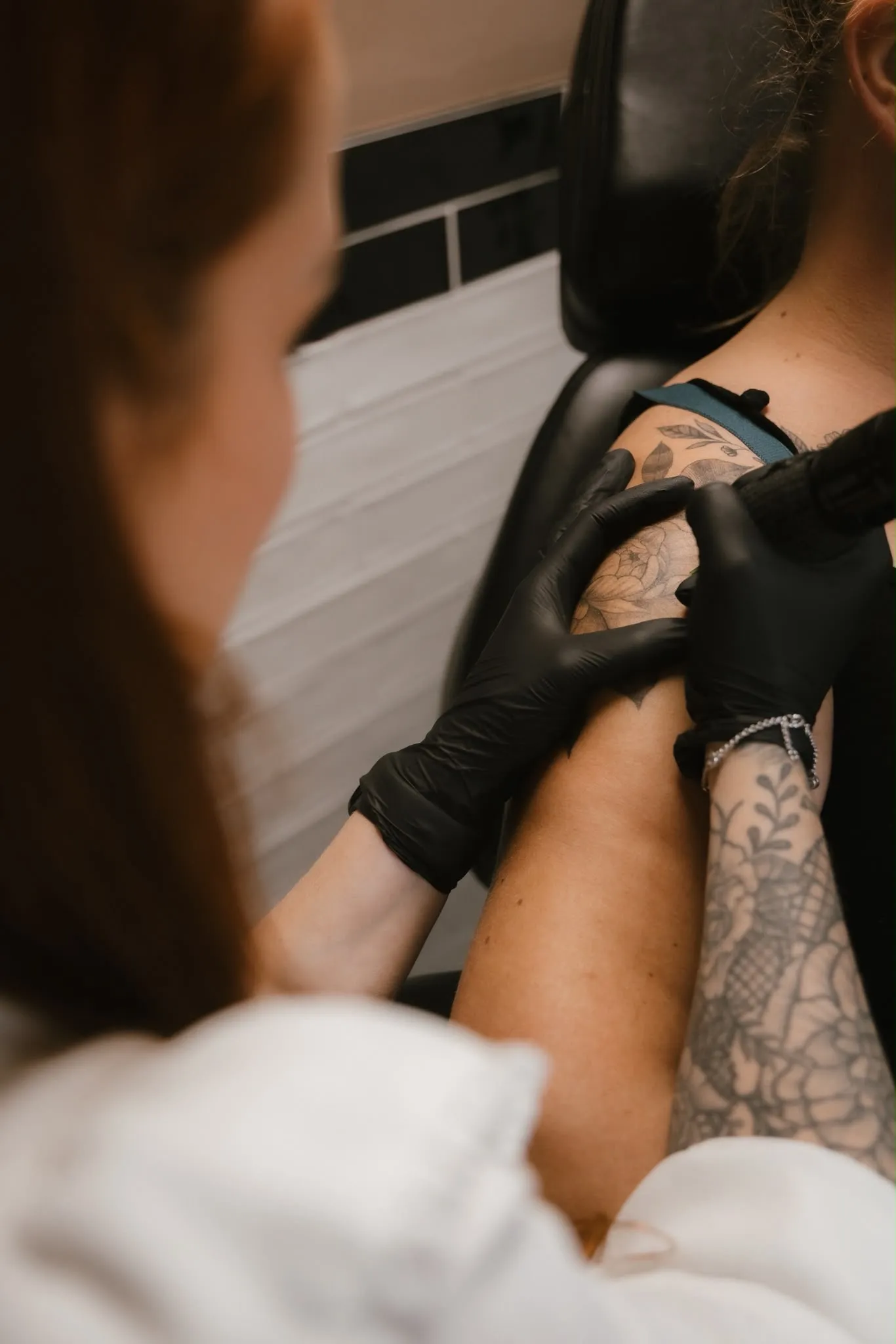 Laura zet een floral tattoo op de schouder in haar privé studio