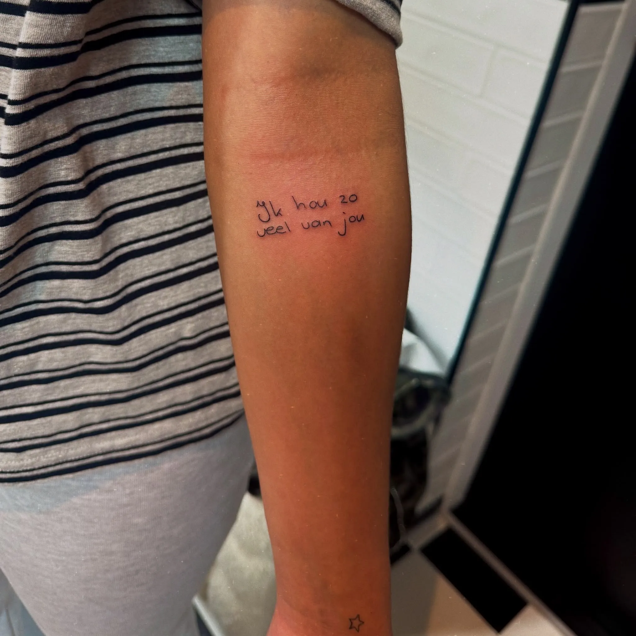 Tekst tattoo "Ik hou zo veel van jou" in persoonlijk handschrift op de onderarm