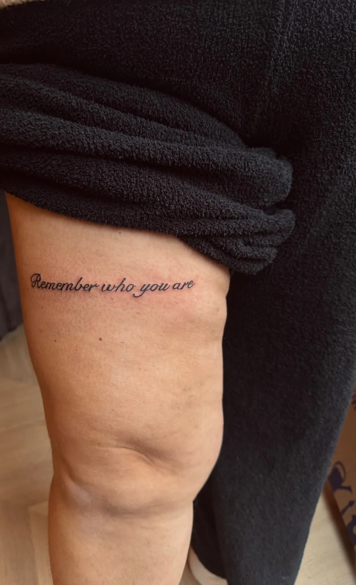 Tekst tattoo Remember who you are op het bovenbeen